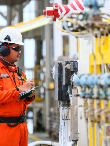 Man in orange suit inspects factory