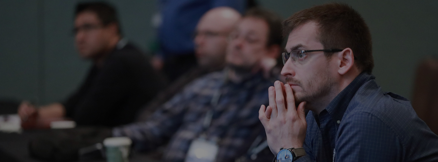 Men listening attentively to conference presentation